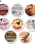 Eight handcrafted cabinet knobs featuring vintage Chicago sports memorabilia designs. Includes Cubs, Bears, Bulls, and Blackhawks logos, tickets, and posters. Retro fan cave hardware set of 8.