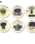 Decorative cabinet knobs in a garden lavender theme featuring rustic baskets and French script on a white base. Ideal handles for a shabby chic bathroom.
