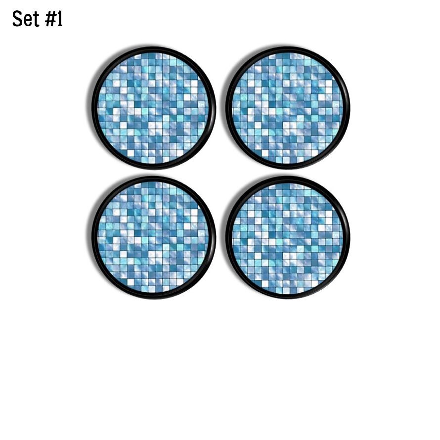 Set of four round cabinet knobs featuring sky blue and white mosaic-style graphics displayed on black wood bases with a high-gloss finish.
