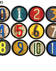 Twelve industrial number cabinet knobs with distressed and worn multicolor accents, designed for rustic, eclectic, modern industrial upgrades and children's decor.