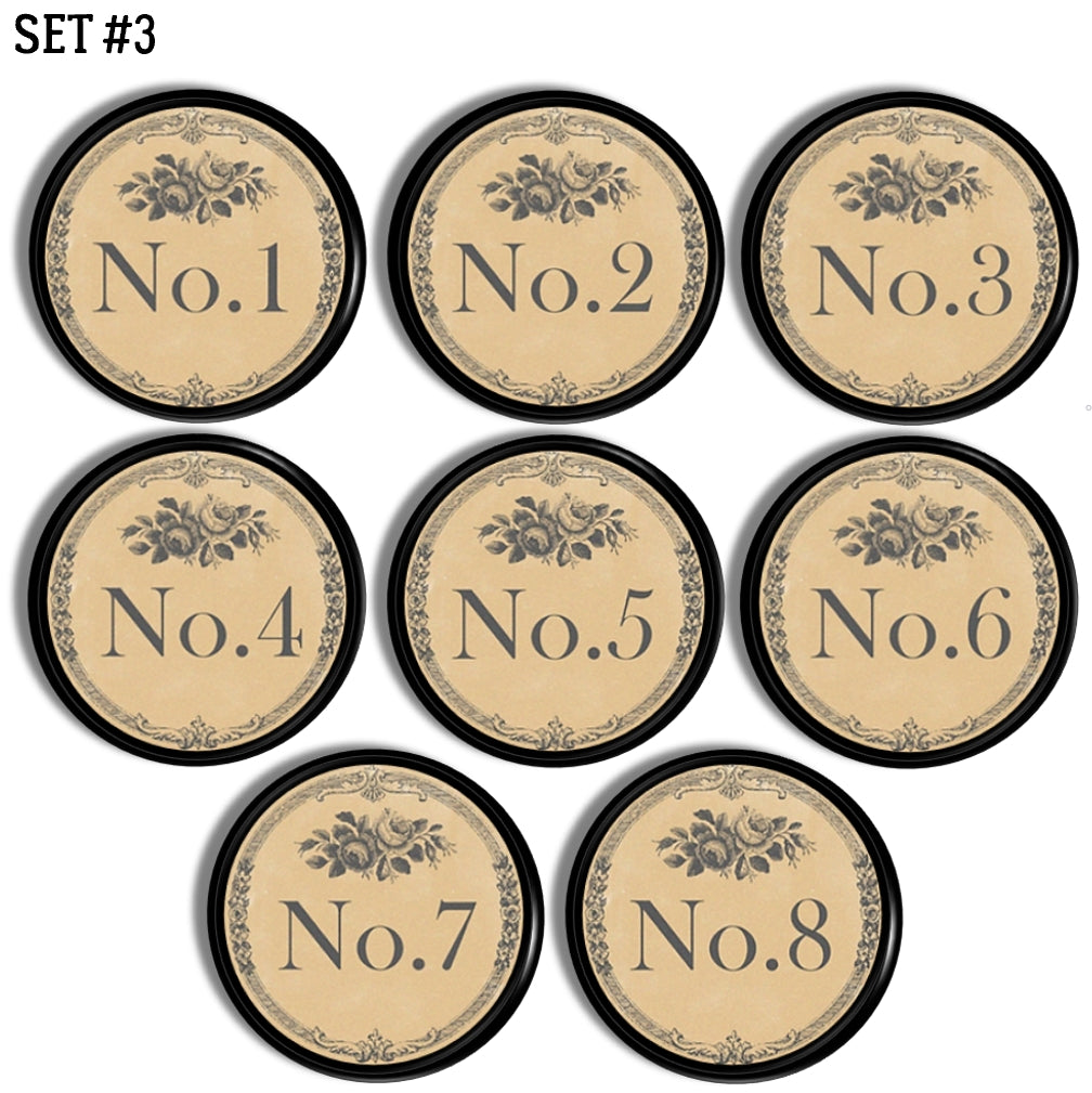 Set of 8 decorative furniture knob hardware. Each round drawer pull is numbered with one number in a series of 1-8 and accented with subtle gray florals. Style is a rustic French inspired to coordinate with vintage industrial, French country or antique farmhouse décor.