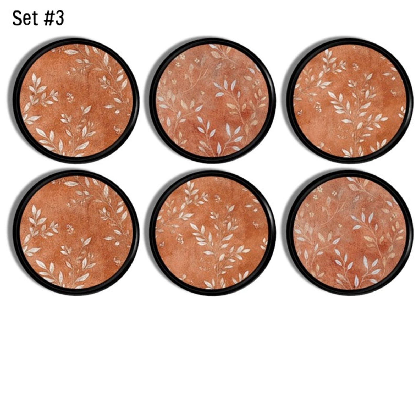 Distressed terracotta inspired cabinet knobs with white botanical leaf designs – nature themed hardware for boho, cottagecore or farmhouse furniture and warm earthy décor.
