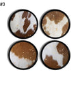 4 decorative cupboard knobs in a cow spot print with subtle gold specks on black base. Southwestern and country western decor.