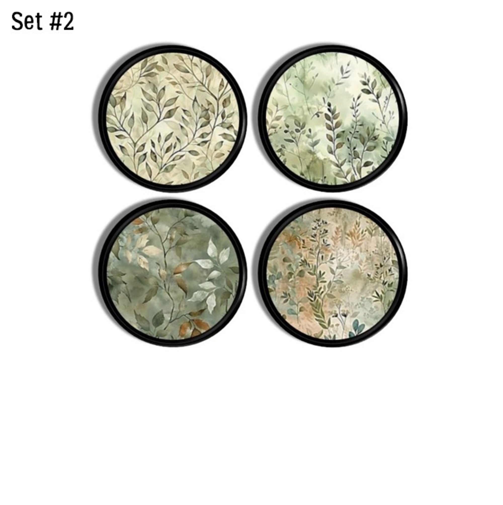Four moody modern cabinet knobs with soft watercolor foliage in sage and beige layered over a deep black base