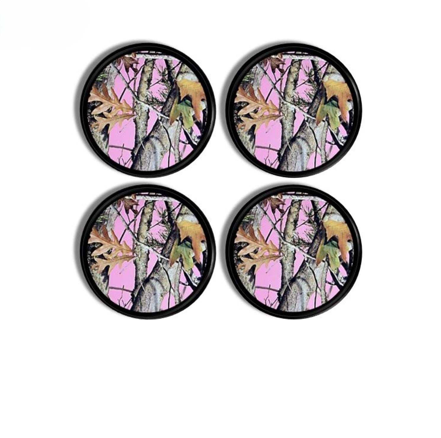 Four black cabinet knobs showcasing bold pink camo with tree bark and leaf textures for modern cabin or lodge décor.