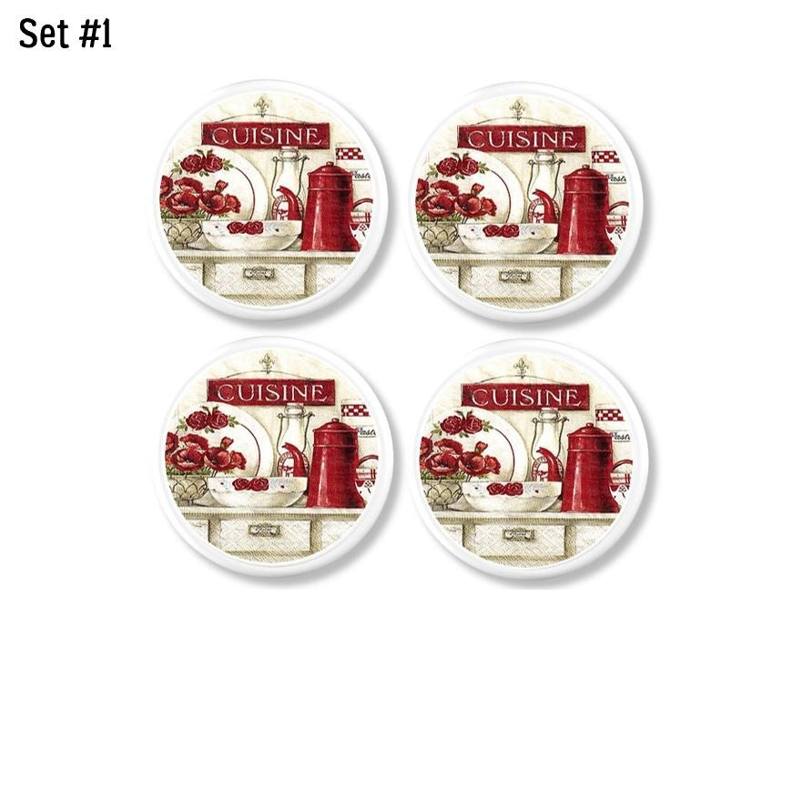 Four white cabinet knobs with red-and-white hospitality kitchen artwork featuring a cozy countertop and CUISINE sign.