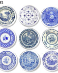 Set of nine blue and white Delft inspired toile cabinet knobs featuring vintage transferware plate motifs with pastoral scenes, architectural landscapes, floral borders, and classic chinoiserie patterns. Ideal for cottagecore or rustic country farmhouse decor.