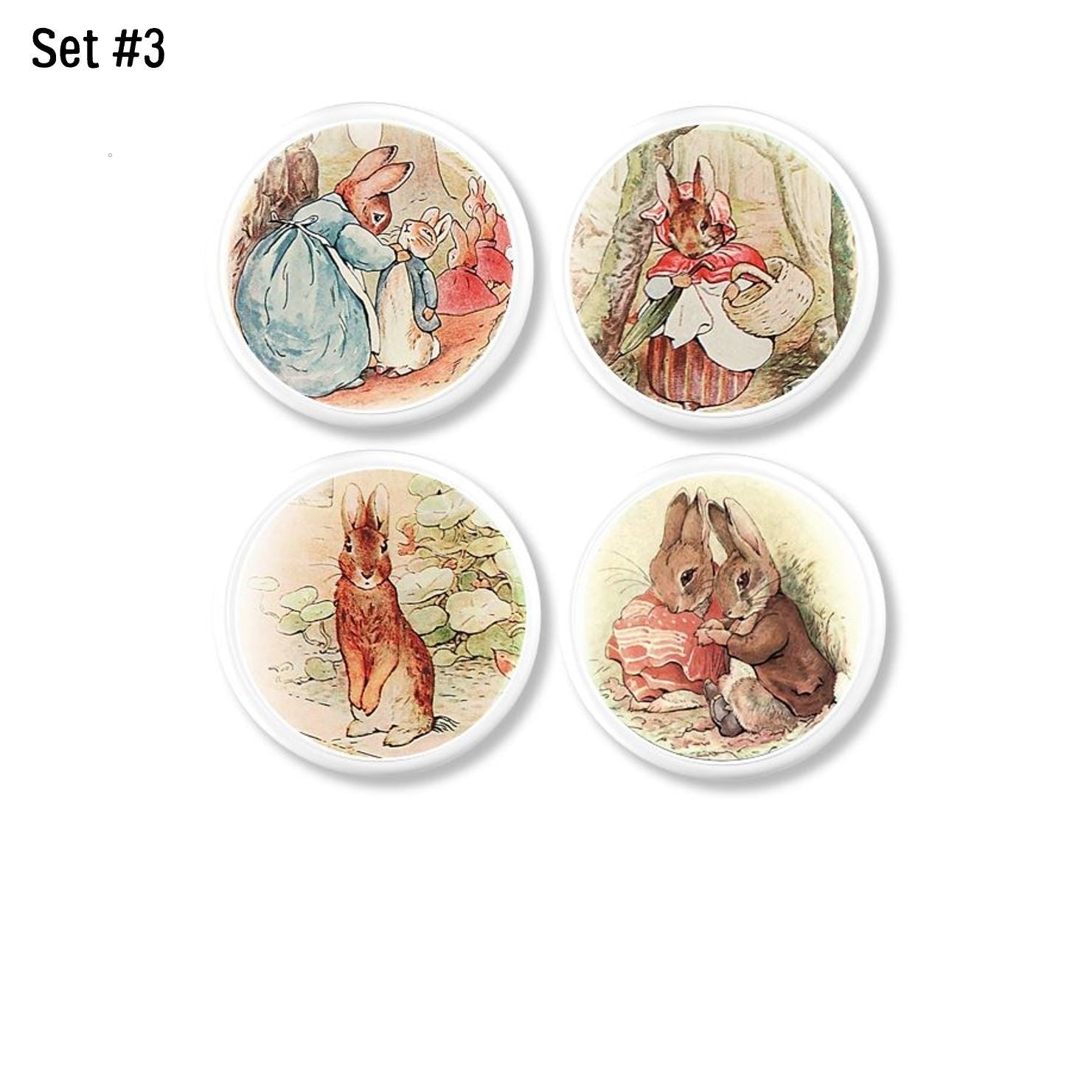 Four handmade cabinet knobs featuring sweet Beatrix Potter rabbit family scenes and character portraits in soft pastel storybook watercolor style.