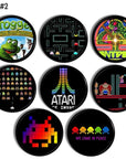 Eight black knobs featuring colorful retro arcade game artwork. Includes Frogger, Pac‑Man, Centipede, Space Invaders, Donkey Kong, Atari logo, pixel aliens, and colorful ghost characters. Handcrafted drawer pulls for gamer pad or entertainment center.