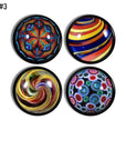 Four handcrafted cabinet drawer pulls featuring simulated vintage glass marbles on a black base knob, with ribbon swirls, spirals, concentric circles, and kaleidoscope motifs in bright retro colors.