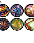 Six handcrafted cabinet drawer pulls featuring simulated vintage glass marble designs on a black base knob, with bold spirals, kaleidoscope bursts, glitter accents, and multicolor swirls inspired by classic retro toy marbles.