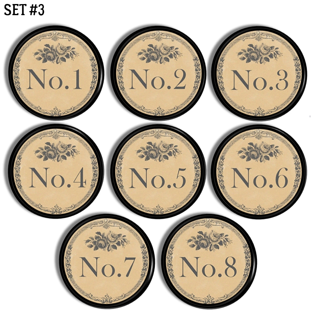Set of 8 decorative furniture knob hardware. Each round drawer pull is numbered with one number in a series of 1-8 and accented with subtle gray florals. Style is a rustic French inspired to coordinate with vintage industrial, French country or antique farmhouse décor. 